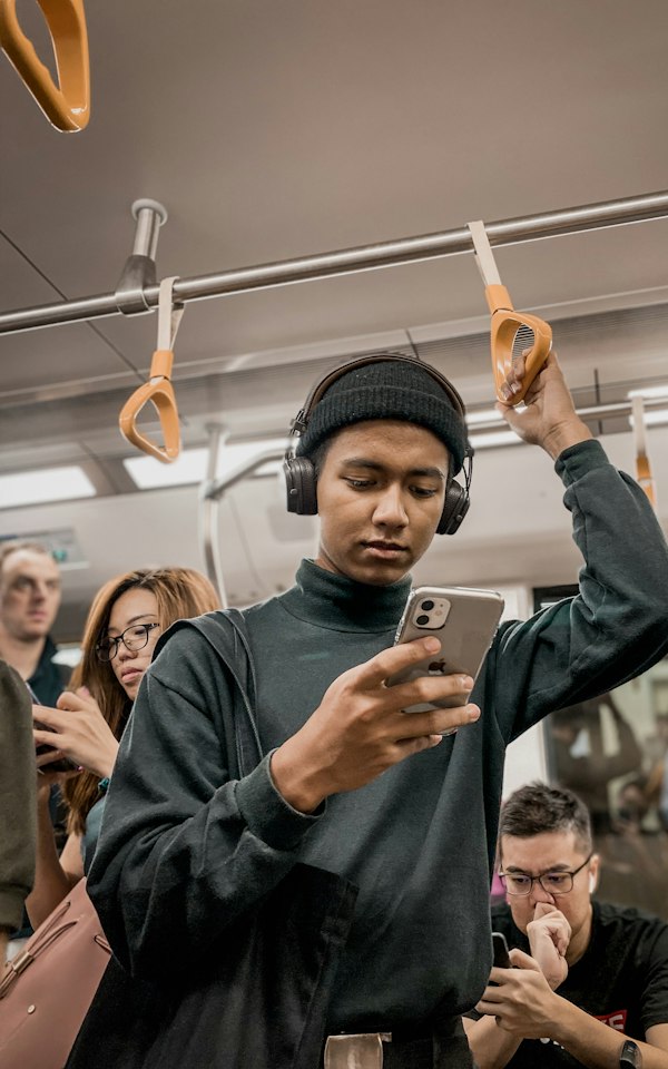 Student checking his phone on a train