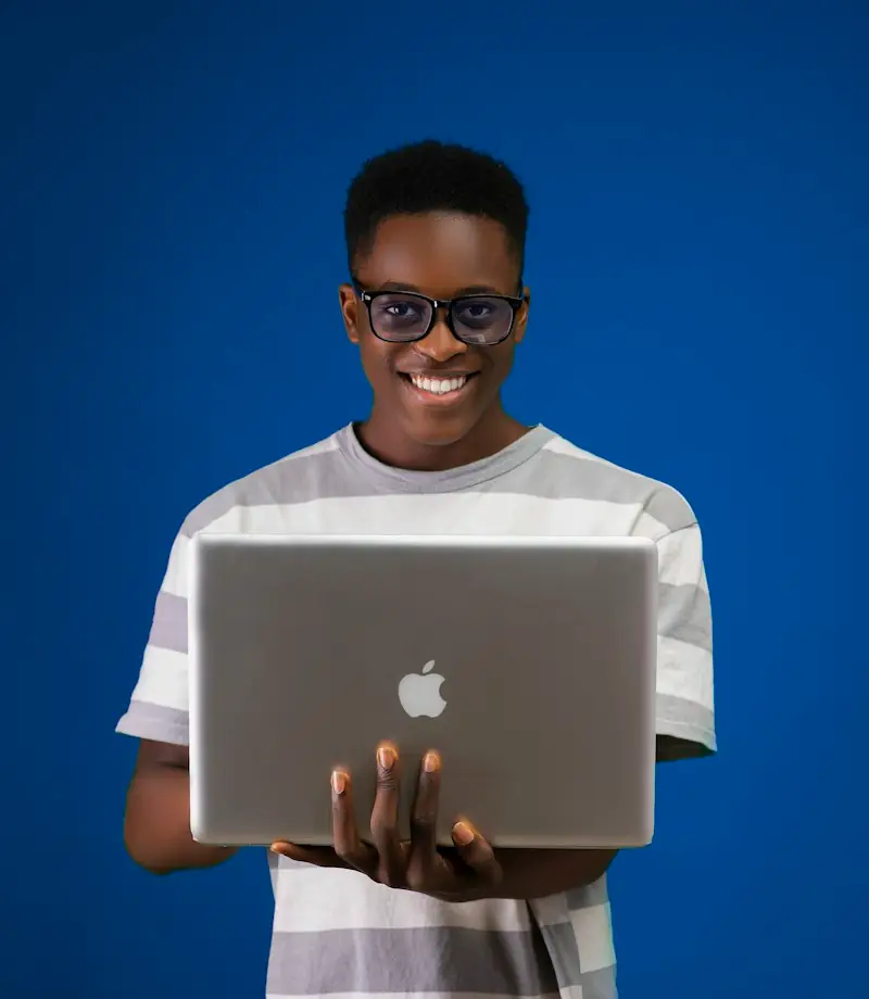 Smiling student holding a laptop